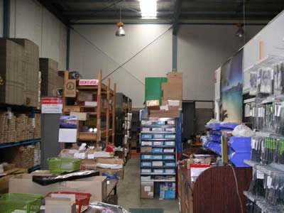 Warehouse before installation of mezzanine floor and in the background, the famous multi-tiered wood shelves built by Alf Deegan